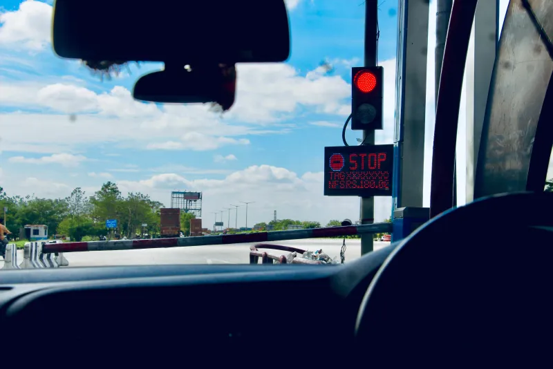 Vista desde un vehículo acercándose a una caseta de peaje